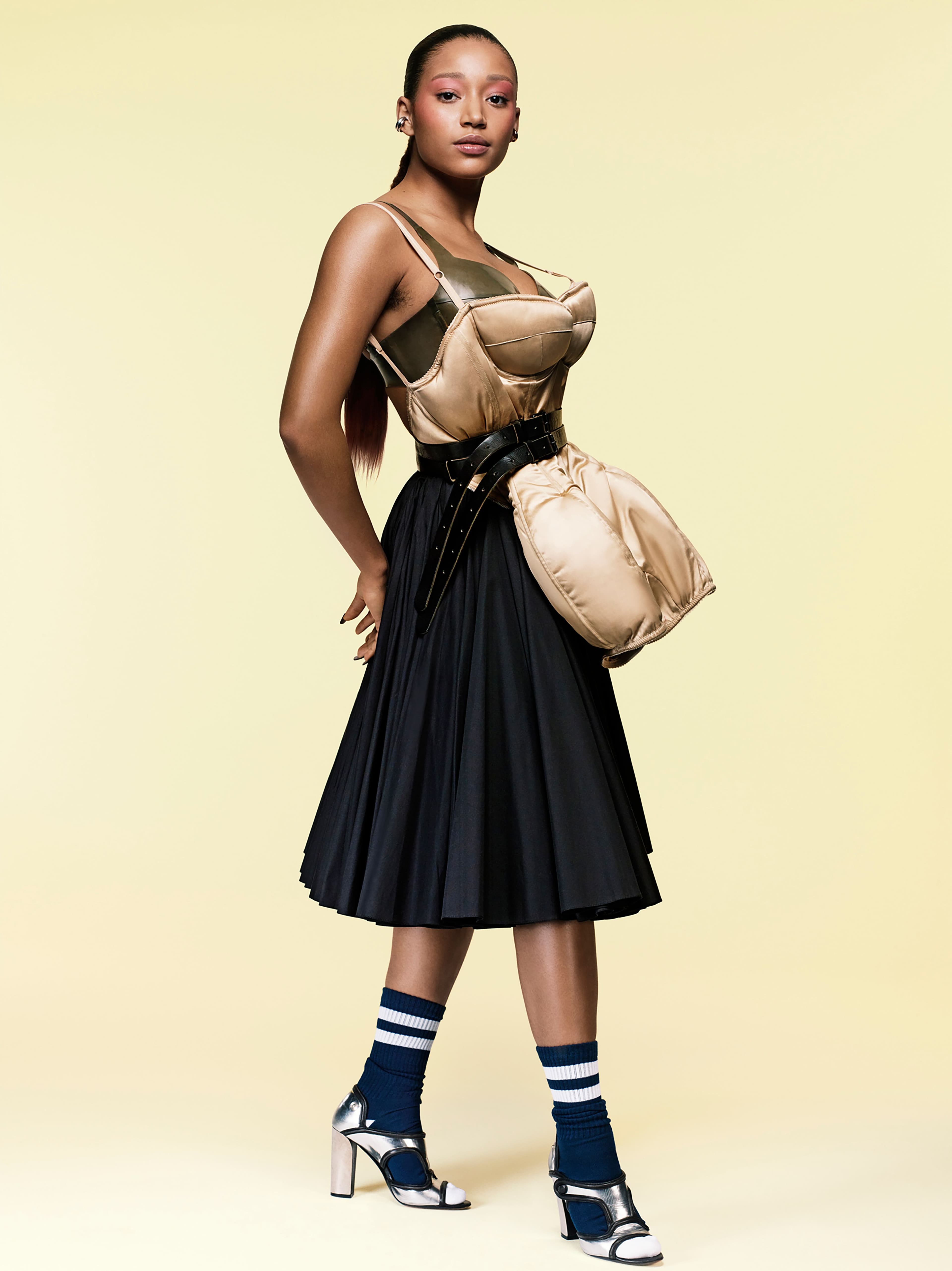 Vintage bodysuit from the Albright Fashion Library. Bra by Atsuko Kudo. Skirt by Emilia Wickstead. Socks by Converse. Vintage shoes by Pierre Hardy from the Albright Fashion Library. Vintage belt by Raf Simons from the David Casavant Archive. Ear cuffs on right ear by, from top, All Blues and Jennifer Fisher. Ear cuff on left ear by Jennifer Fisher.